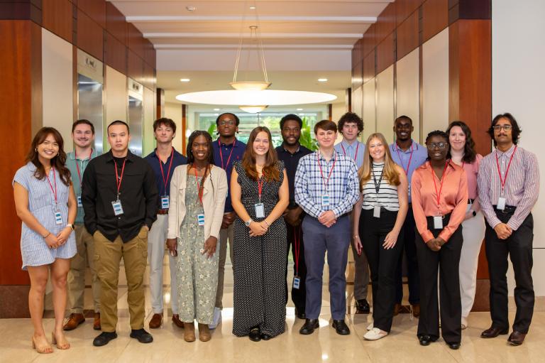Fifteen young adult men and women posing for a group photo at VITA.